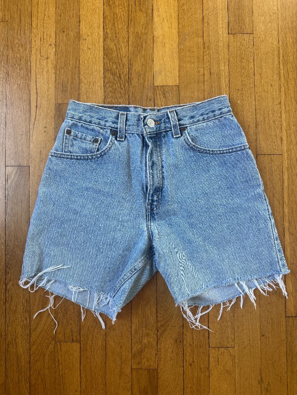 Vintage early 90s Levi's 550 blue denim cutoff classic shorts with raw hem